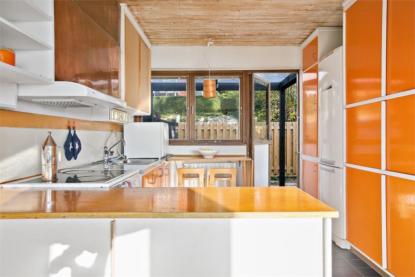 1960s architect-designed modernist property orange and wood kitchen